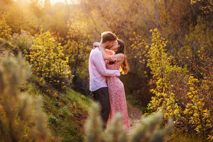 Engagement photoshoot of young couple embracing at sunset