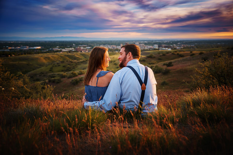 Couple gazes into each others' eyes at sunset in field at Boise's Military Reserve Park for engagement session