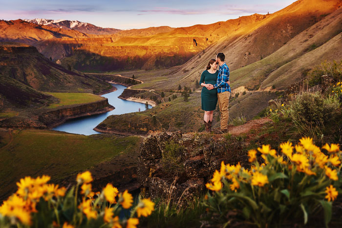 Young couple standing by canyon outside Boise Idaho for maternity photoshoot