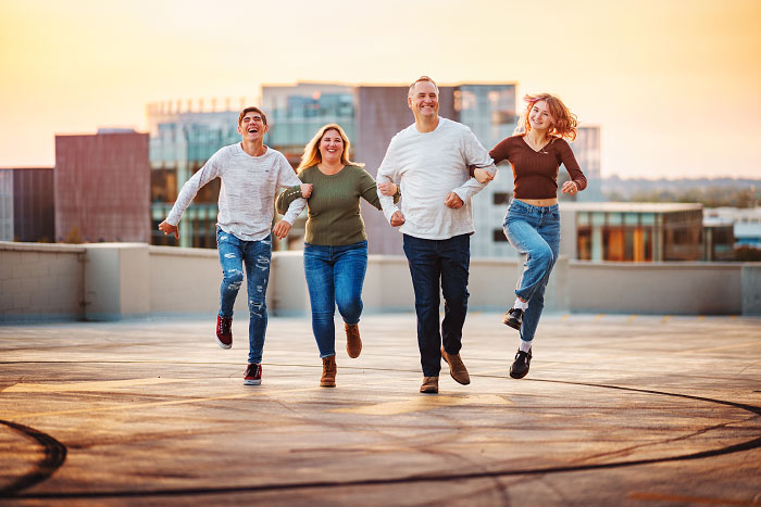 Family of four skips and laughs on parking garage rooftop in downtown Boise