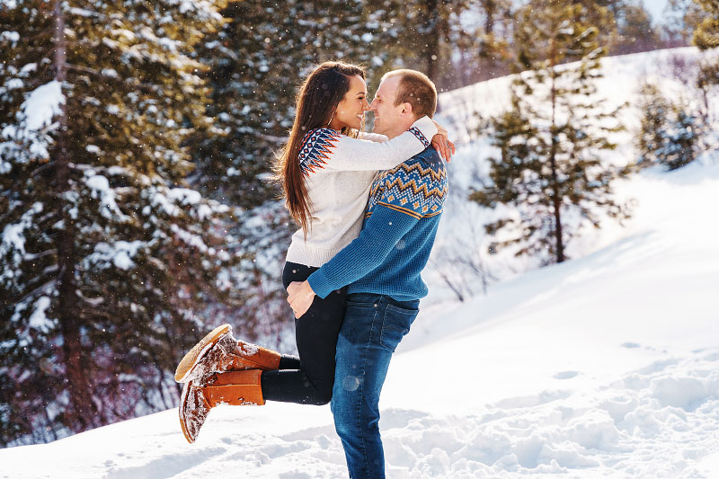 Laughing man and woman nose to nose in embrace in snowy Idaho landscape