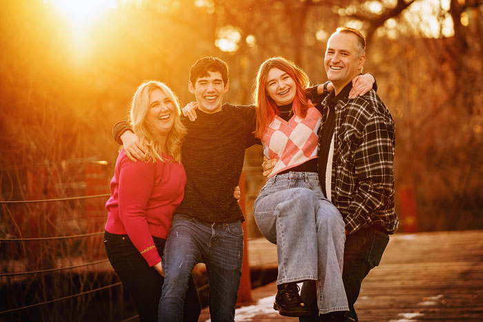 Parents pick up two teenage kids for sunlit family photoshoot