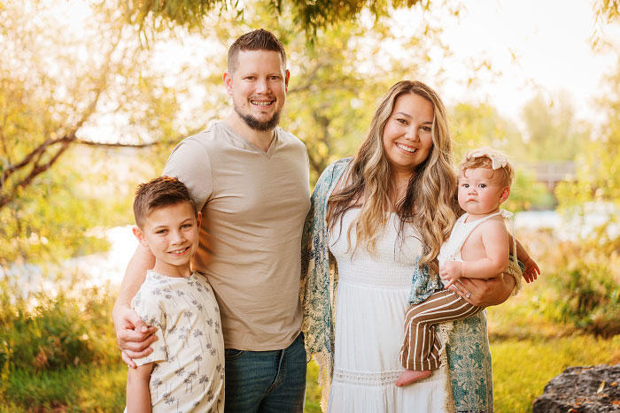 Portrait of young family of four under willow tree in Idaho