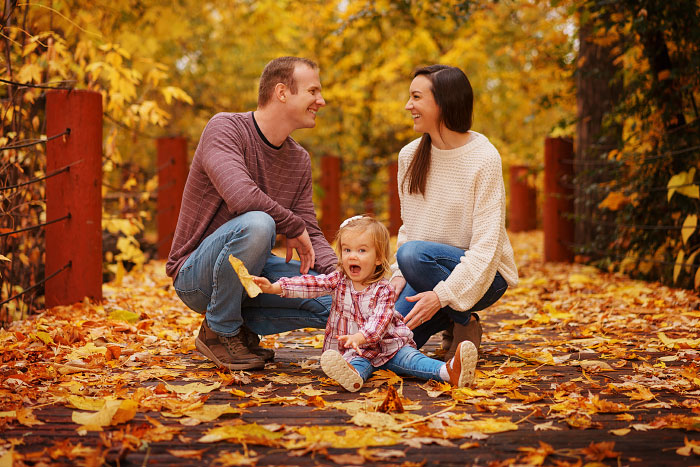 Parents with young child holding leaf by Boise River Greenbelt