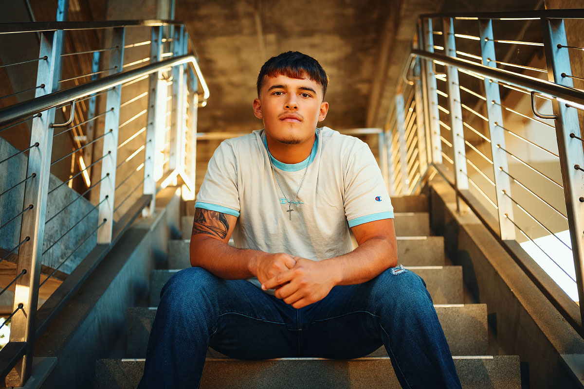 Teen boy sits on steps during senior session at JUMP Boise