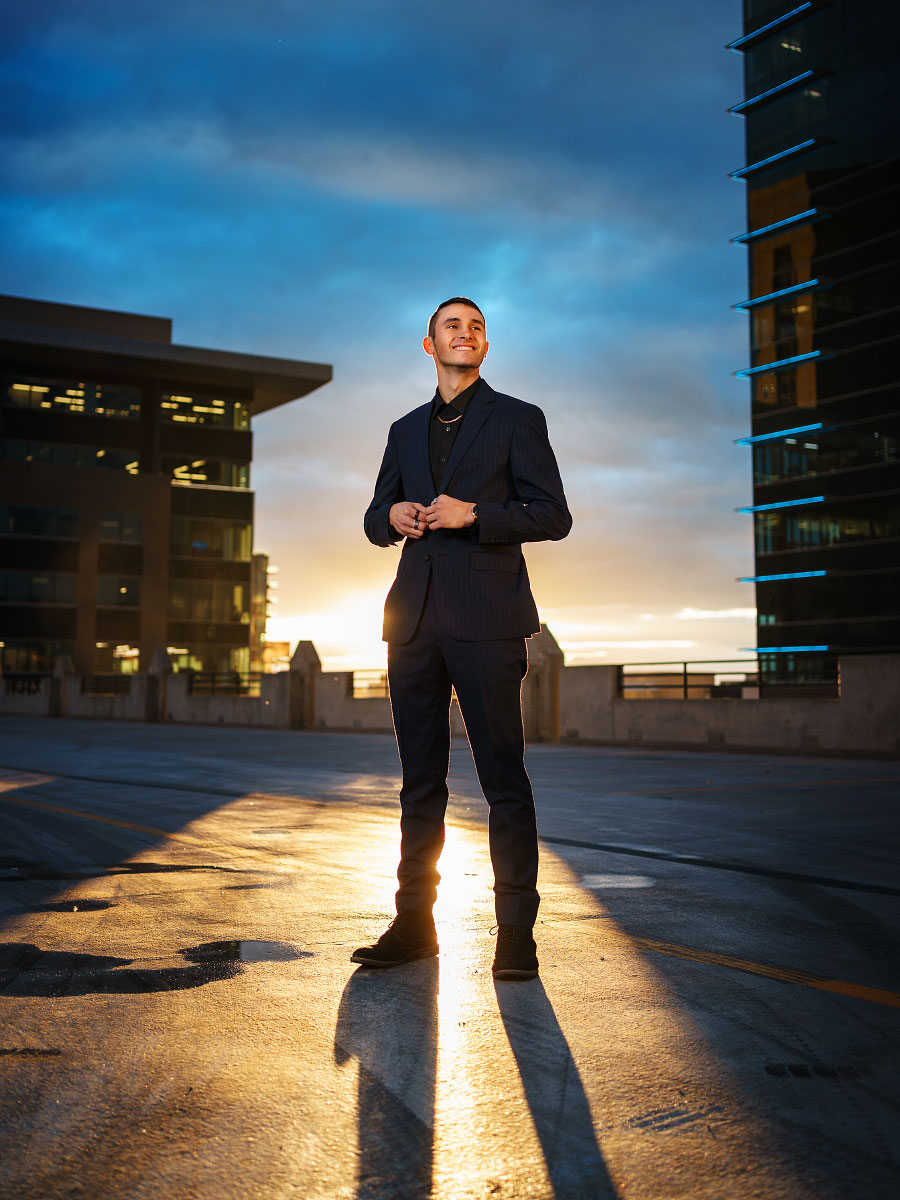 Senior boy on parking garage rooftop at sunset in downtown Boise
