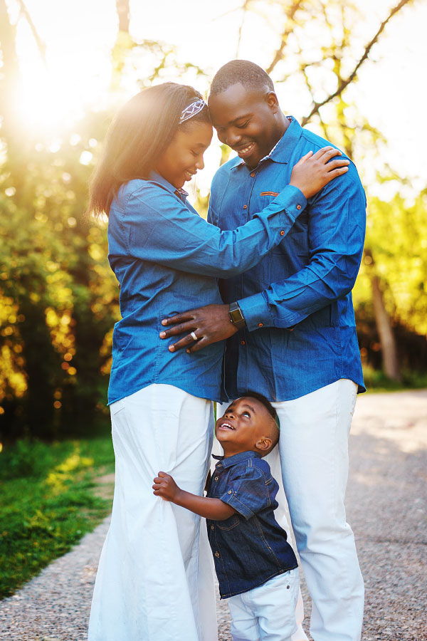 Mom and Dad with young son looking up at them lovingly on family photoshoot