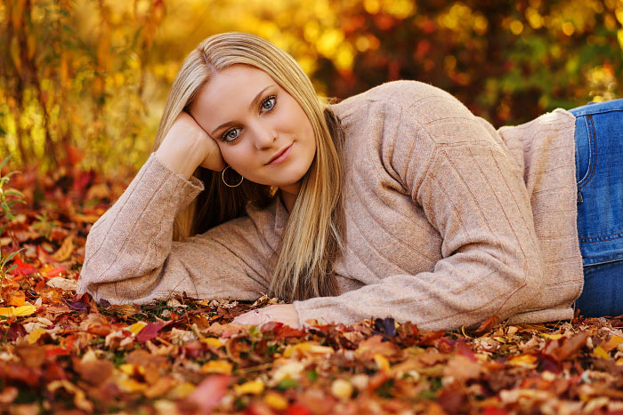 Senior photo of teen girl posing in leaves at Kathryn Albertson Park in Boise ID